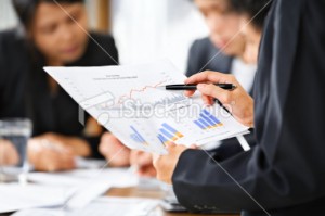 stock-photo-10215093-examining-graphs-with-other-people-on-background